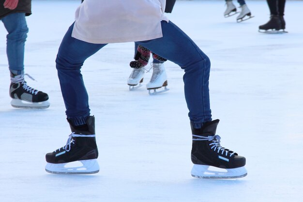 Pies sobre los patines de una persona que rueda sobre la pista de hielo.