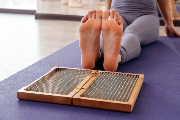 Pies y tabla de madera con clavos metálicos afilados. Tablero de pie de Sadhu. Entrenamiento de práctica de relajación de yoga