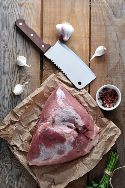 Pieza cruda de jamón grande de cerdo y un gran cuchillo para picar