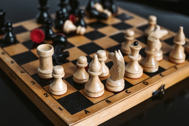 Piezas de ajedrez de madera antiguas en el tablero de ajedrez durante el proceso de juego