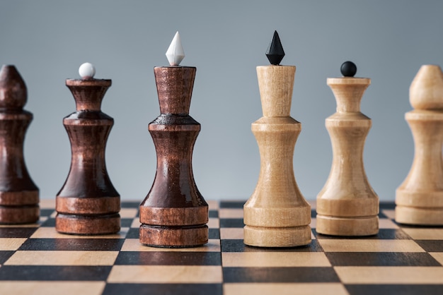 Foto piezas de ajedrez de madera sobre un tablero de ajedrez, dos reyes uno al lado del otro, el concepto de estrategia, planificación y toma de decisiones