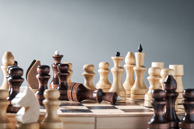 Piezas de ajedrez de madera en un tablero de ajedrez, el enfrentamiento del peón blanco y la reina negra, concepto de planificación y toma de decisiones