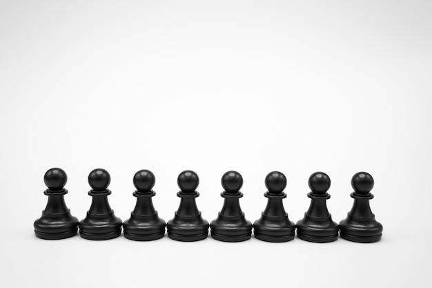 Piezas de ajedrez negras sobre superficie blanca.