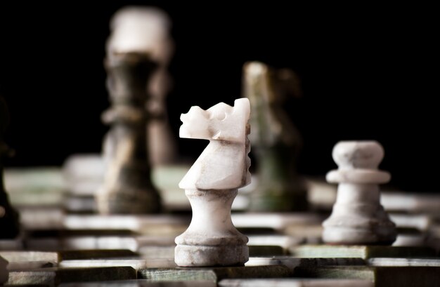 Piezas de ajedrez sobre un tablero de mármol.