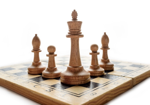 Piezas de ajedrez en un tablero sobre un fondo blanco con espacio de copia.