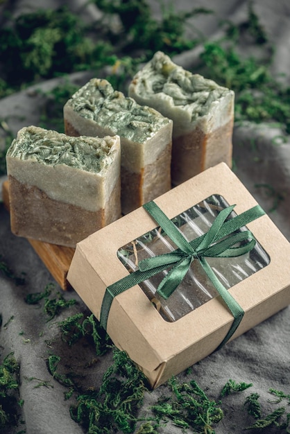 Foto piezas de auténtico jabón orgánico artesanal en un plato de jabón de madera rodeado de musgo verde