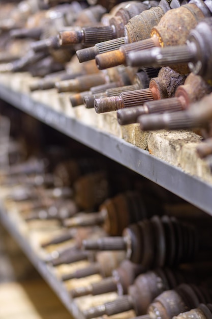 Piezas de automóviles usados en el estante de la fábrica. Autopartes usadas a la venta en una tienda en un vertedero. Musarañas, semi-eje de transmisión de automóviles. Desmontaje de coches.