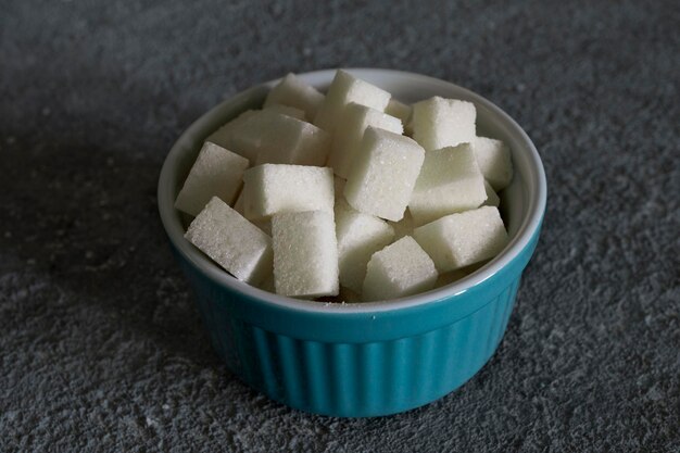 Foto piezas de azúcar refinado en un cuenco materia prima culinaria de primer plano