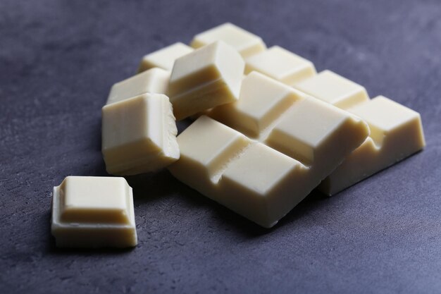 Foto piezas de chocolate blanco sobre un fondo gris