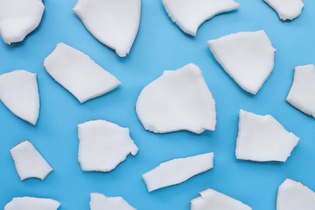 Foto piezas de corte de coco sobre fondo azul.