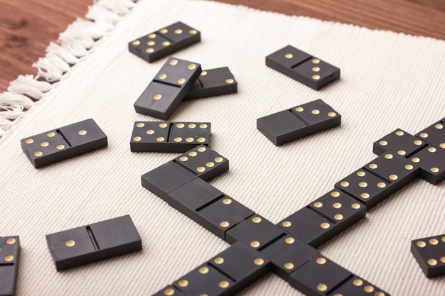 Foto piezas de dominó en negro sobre una mesa de luz