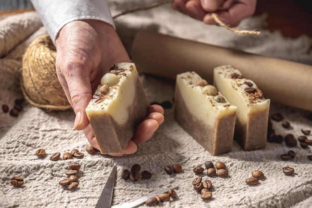 Piezas fragantes de jabón de café natural con granos de café cuerda papel artesanal y tijeras sobre la mesa Concepto de un pasatiempo interesante y embalaje de regalos ecológicos hechos a mano