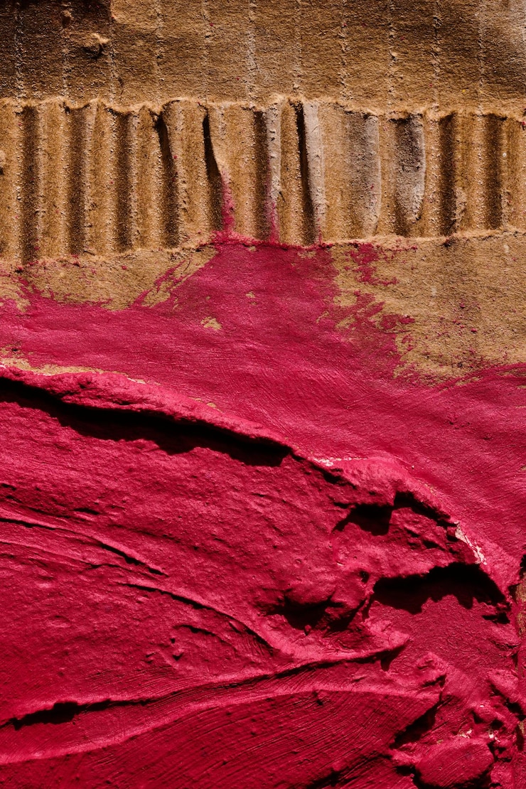 Foto piezas irregulares rojas de cartón de fondo abstracto, guiones de pintura caótica y trazos sobre yeso aplicado con textura de masilla de espátula