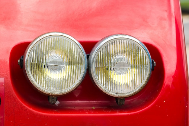 Piezas de la lámpara delante del coche rojo vintage.