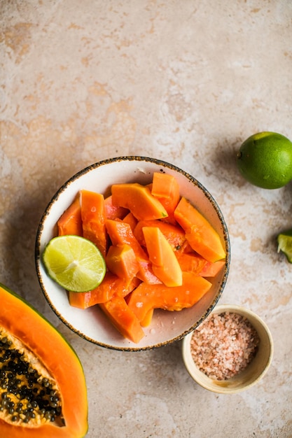 Piezas de papaya con lima y sal en el plato para cocinar comida