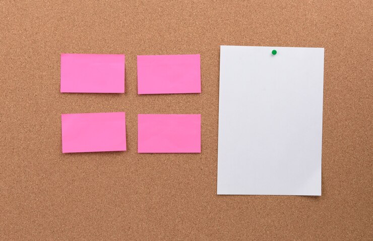 Foto piezas de papel en blanco rosa y blanco vacías clavadas en un tablero de corcho, espacio de copia