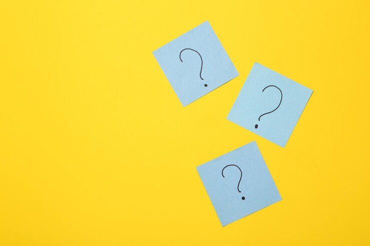 Foto piezas de papel con signos de interrogación en un fondo amarillo concepto de respuestas de psicología empresarial a preguntas