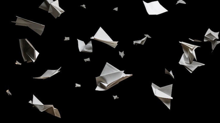 Foto piezas de papel volando en el aire con fondo negro sólido