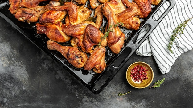 Piezas de pollo al horno al horno, alas y piernas en la bandeja para hornear, comida casera comida sabrosa y abundante