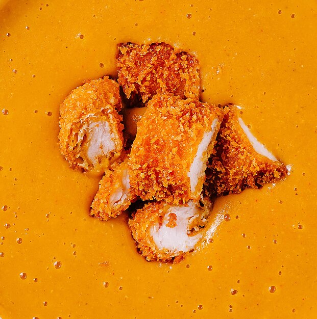 Piezas de pollo crujientes servidas en una rica salsa de curry dorado