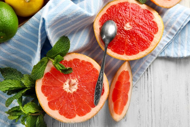 Foto piezas de pomelo con cuchara sobre un fondo ligero de madera