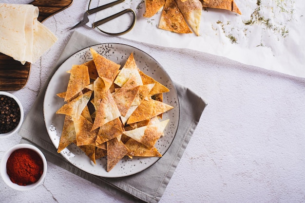 Pikante Chips mit Paprika und Dill aus Fladenbrot auf einem Teller von oben