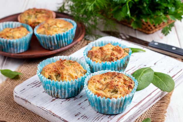 Pikante Muffins mit Feta-Käse und Spinat auf einer Holztafel