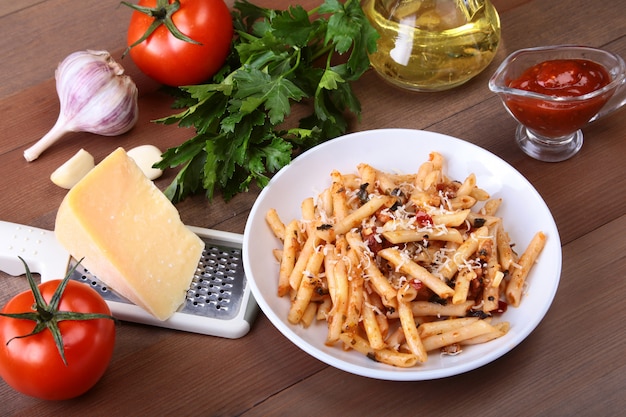 Foto pikante pasta penne bolognese mit gemüse, chili und käse in tomatensauce.