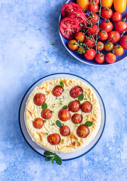 Pikanter Käsekuchen mit Tomaten dekoriert mit Minze