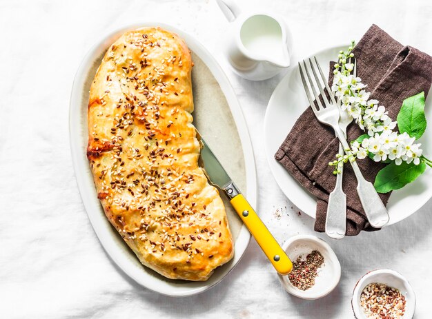 Pikanter Strudel aus Blätterteig mit Kohlbrokkoli und Mozzarella-Käse, serviert auf einem weißen Tisch