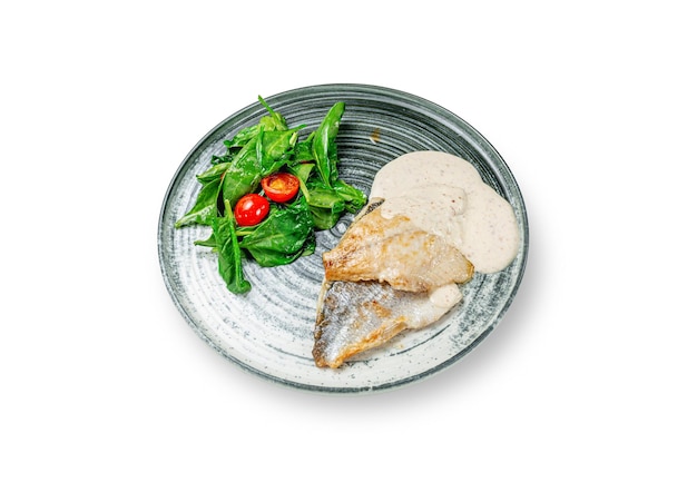 Pikeperch dourado de peixe grelhado com purê de creme e molho, com salada de espinafre e tomate cereja em um prato em um fundo branco isolado