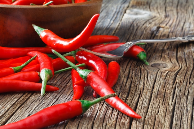 Pila de ají rojo en tenedor pone sobre la mesa rústica