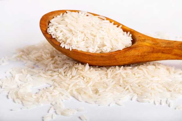 Pila de arroz basmati en una cuchara de madera