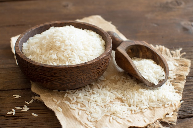 Pila de arroz Basmati en un recipiente con una cuchara de cerca