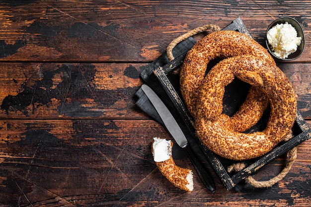 Pila de bagel simit turco recién horneado con kaymak. Fondo de madera. Vista superior. Copie el espacio.