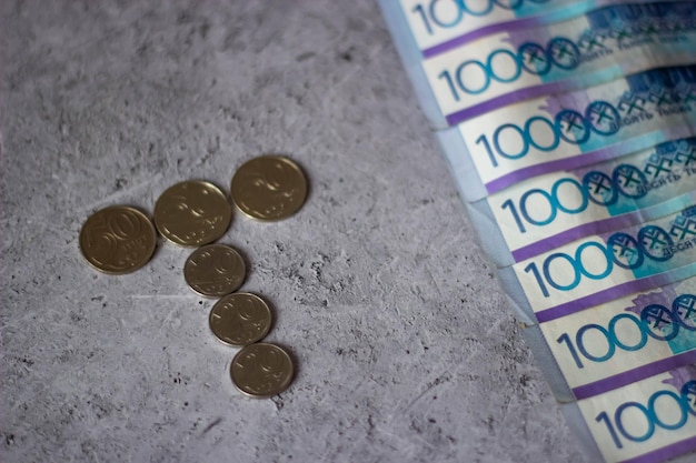 Una pila de billetes de 100 euros junto a una pila de monedas.