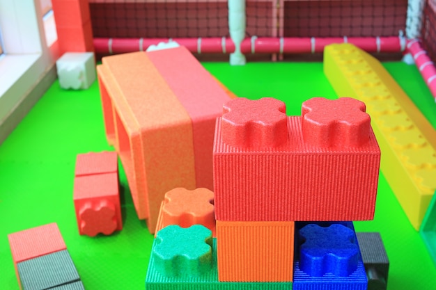 Foto pila de bloques grandes coloridos que construyen espuma de los juguetes. educación preescolar de recreo cubierto.