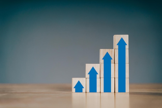 Pila de bloques de madera con gráficos de flecha creciente Desarrollo empresarial al concepto de éxito