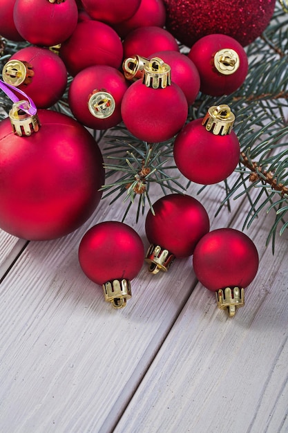 Pila de bolas rojas de navidad en rama de pino y pizarras blancas