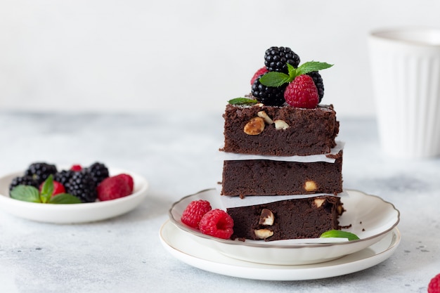 Pila de brownies de chocolate con frambuesas y moras