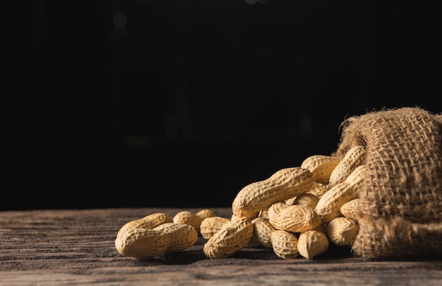 Pila de cacahuetes, pila de cacahuetes en mesa de madera