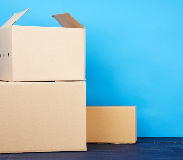 Foto pila de cajas de cartón de papel kraft marrón sobre una mesa de madera azul