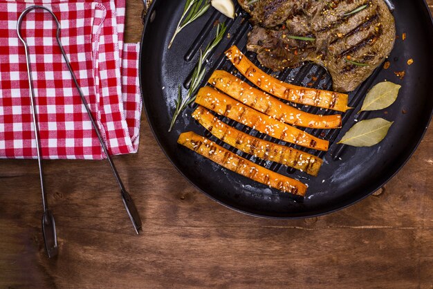 Pila de carne frita y zanahorias en una sartén redonda