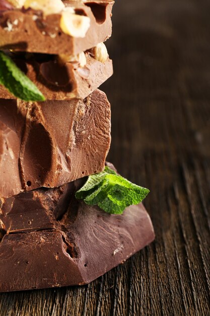 Pila de chocolate con nueces en primer plano de la mesa de madera