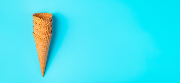 Una pila de copas de helado de gofre sobre un fondo azul claro