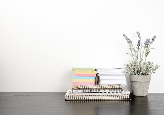 Foto una pila de cuadernos en espiral y pegatinas de colores al lado de una olla de cerámica