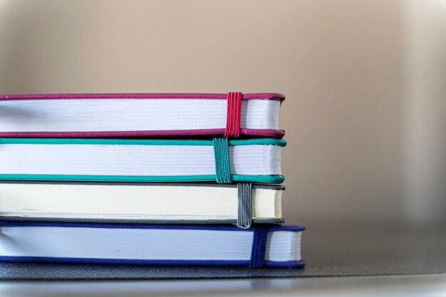 Foto pila de cuadernos multicolores y lápiz en la mesa de la oficina