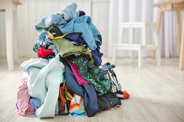 Pila de roupas coloridas no chão dentro de casa