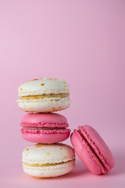 Pila de deliciosos macarons rosados y blancos franceses de diferentes sabores