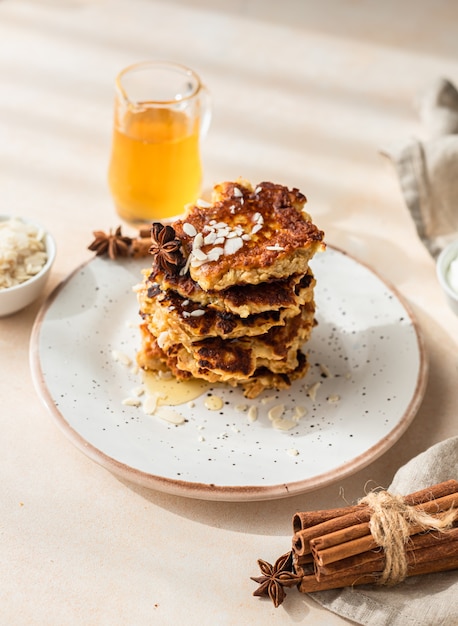 Pila de deliciosos panqueques de manzana o buñuelos con miel, especias y almendras Desayuno de otoño